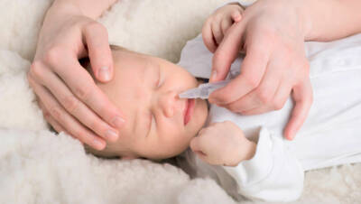leżące niemowle podczas zakrapiania nosa